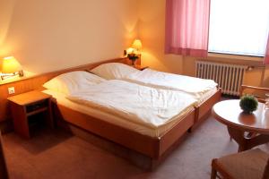 ein Schlafzimmer mit einem großen Bett mit weißer Bettwäsche in der Unterkunft Hotel Niederée in Bad Breisig
