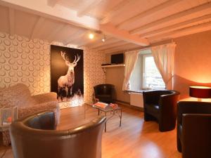 a living room with a deer painting on the wall at Country house in the Ardennes with Schwimmbad in Warempage