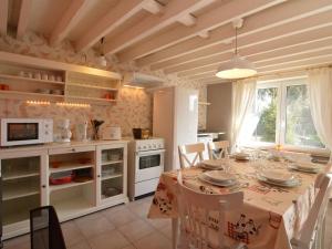 a kitchen with a table with chairs and a kitchen with white appliances at Country house in the Ardennes with Schwimmbad in Warempage