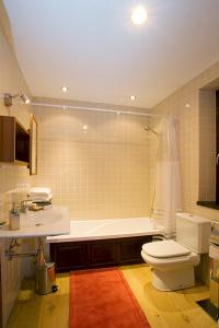 La salle de bains est pourvue de toilettes, d'une baignoire et d'un lavabo. dans l'établissement Hotel y apartamentos rurales L'Anceo, à Cibuyo