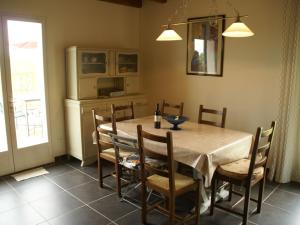 a dining room with a table and chairs and a kitchen at Modern holiday home with private pool in Loubressac