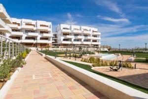 a large white apartment building with a courtyard at Terrazas de Campoamor by Mar Holidays in Playas de Orihuela