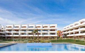 a large white apartment building with a swimming pool at Terrazas de Campoamor by Mar Holidays in Playas de Orihuela