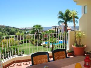 a balcony with a view of a pool and palm trees at Belvilla by OYO El Mirador in Alhaurín el Grande