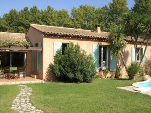 ノヴにあるColourful Holiday Home in Noves with Swimming Poolの庭園とパティオ付きの家