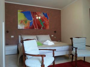 Borghesiana にあるCasa Livia Metro C Bolognettaのベッドルーム1室(ベッド1台、椅子2脚、絵画付)