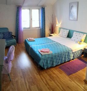 a bedroom with a large bed and a chair at Apartments Dandolo in Rovinj