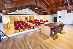 una sala conferenze con sedie rosse e un palco di Albergo Diffuso "Col Gentile" Socchieve a Priuso