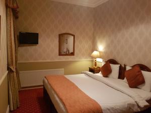 a hotel room with a large bed and a mirror at Royal Spa Hotel in Lisdoonvarna