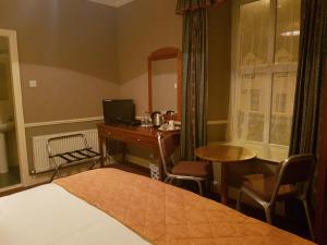 a bedroom with a desk and a computer and a bed at Royal Spa Hotel in Lisdoonvarna