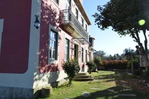 a pink building with a balcony on the side of it at Solar da Motta Douro Boutique Home in Ancede
