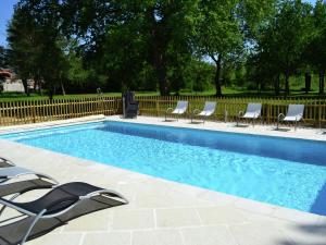 a swimming pool with chairs and a fence at Cozy Holiday Home in Brion with Swimming Pool in Brion