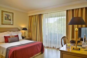 pokój hotelowy z łóżkiem i dużym oknem w obiekcie Hotel Cascais Miragem Health & Spa w mieście Cascais