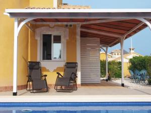 two chairs sitting on a porch next to a pool at Villa in Costa Cálida with Private Pool in Mazarrón