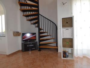 a living room with a staircase and a tv at Luxurious Holiday Home in Mazarron with Private Pool in Mazarrón