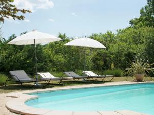 CéresteにあるRustic villa with pool in Cereste Franceのプールサイドの椅子2脚とパラソル2本