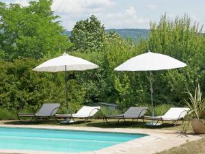 CéresteにあるRustic villa with pool in Cereste Franceのプールサイドの椅子2脚とパラソル2本