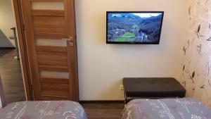a room with a tv on the wall and a bed at Tehvandi Ski Apartment in Otepää