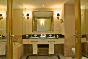 a bathroom with a sink and a tub and a mirror at Hotel Cascais Miragem Health & Spa in Cascais