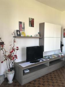 a living room with a tv and a cabinet at Casa del Faggio Rosso in Bellagio
