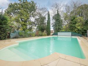 een groot zwembad met blauw water in een tuin bij Charming holiday home with pool in Monbazillac