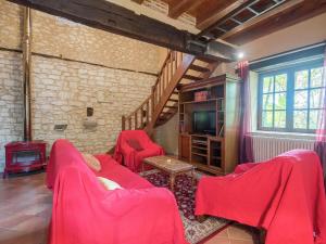 a living room with red furniture and a tv at Charming holiday home with pool in Monbazillac