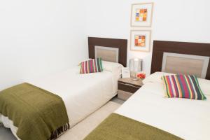 サン・ファン・デ・ロス・テレロスにあるMar de Pulpí Las Azucenas by Mar Holidaysのベッドルーム1室(ベッド2台、ランプ付きテーブル付)