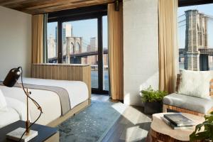 a bedroom with a bed and a view of the city at 1 Hotel Brooklyn Bridge in Brooklyn