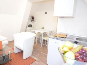 una cocina blanca con un bol de fruta en la barra en Charming holiday home near the ski area, en Schmallenberg