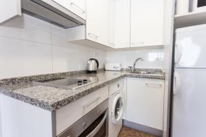 a kitchen with white cabinets and white appliances at Pio XII Apartments Valencia in Valencia