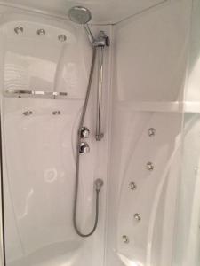 a shower with a shower head in a bathroom at Bed & Breakfast Klokgaaf in De Koog