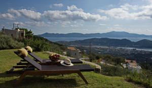 un banco sentado en la cima de una colina con vistas en Agia Kali Villas, en Skiathos
