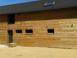 a wooden building with four windows and a black roof at Modern Holiday Home in Sourbrodt with Private Pool in Sourbrodt