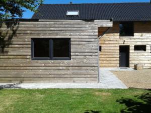 a wooden building with two windows and a yard at Modern Holiday Home in Sourbrodt with Private Pool in Sourbrodt