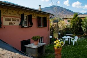 a house with a table and chairs in the yard at B&B Da Beppe in Neirone