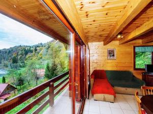 een woonkamer met een bank en een balkon bij Serene holiday home in Dolu with private garden in Brod Moravice