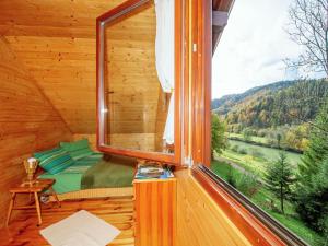 een slaapkamer met een raam in een blokhut bij Serene holiday home in Dolu with private garden in Brod Moravice