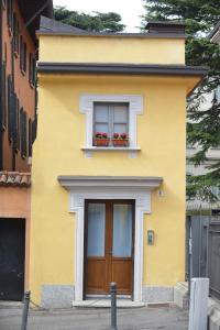 un edificio amarillo con puerta y ventana en Lora Luxury House, en Como