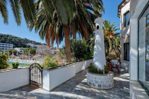 a balcony with a lighthouse and palm trees at Apartments Villa Domus Marini in Hvar