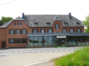 a large red brick building with a road in front of it at Former hotel in Malmedy with indoor swimming pool in Xhoffraix