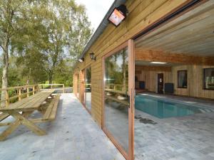 Casa de madera con piscina y mesa de picnic en Former hotel in Malmedy with indoor swimming pool, en Xhoffraix