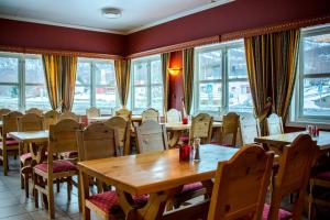 a restaurant with tables and chairs and windows at Tysfjord Hotel in Storjord I Tysfjord
