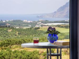 a blue vase sitting on a table with a book and a glass at Modish Villa in Lefkogia Crete with Swimming Pool in Lefkogeia