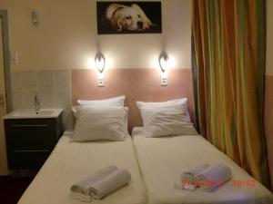two beds in a hotel room with a dog on the wall at Budget Hotel Neutraal in Amsterdam
