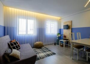 ポルトにあるBOUTIQUE RENTALS - Provence Apartmentの青と白の壁のリビングルーム(テーブル付)
