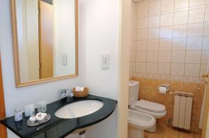 a bathroom with a sink and a toilet at Hotel Punta Condor in San Carlos de Bariloche