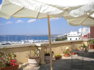 a balcony with an umbrella and a view of a harbor at Palazzo Vergine - by Inside Salento in Gallipoli