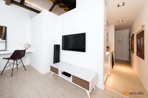 een woonkamer met een tv aan een witte muur bij Petrus Apartment in Toledo