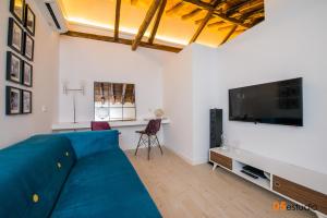 a living room with a blue couch and a flat screen tv at Petrus Apartment by Toledo AP in Toledo