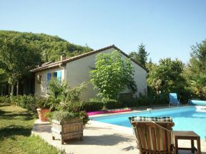 a swimming pool with two chairs and a house at Beautiful holiday home with courtyard in Calamane